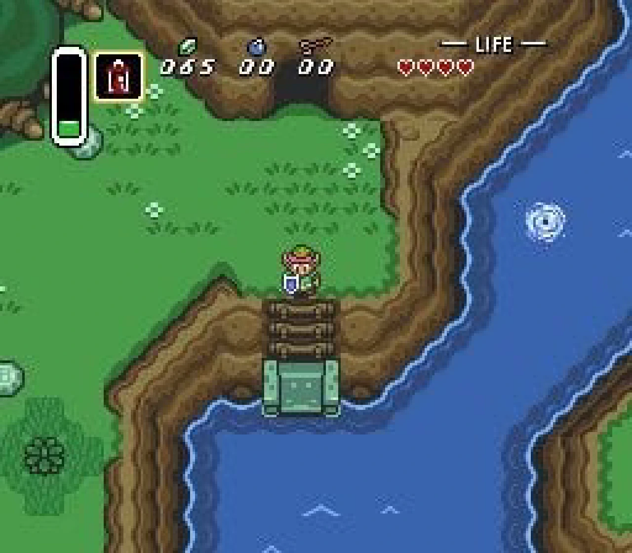 Link crossing a wooden bridge beside a river with the item and life HUD visible in A Link to the Past.